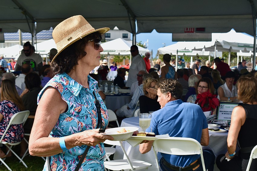 Kiwanis member Deborah DiCarlo heads back to her table with two more plates.