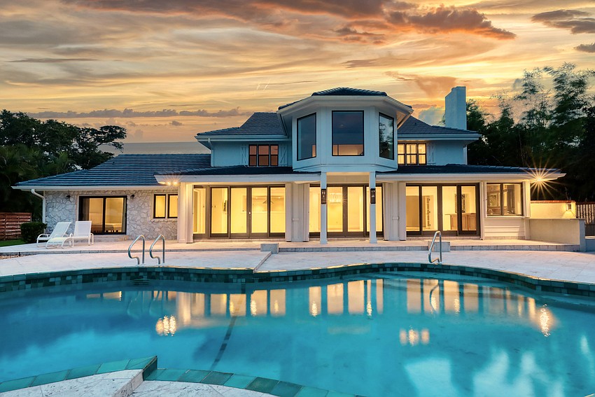 Large floor-to-ceiling windows overlook the pool deck and the bay beyond.
