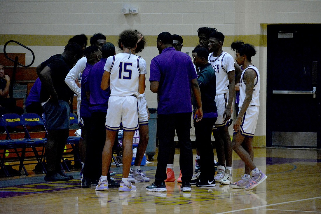 The Booker High boys basketball team huddles during a timeout against North Port High on Tuesday. The Tornadoes came back from and eight-point deficit to tie the game at 40 before ultimately losing.