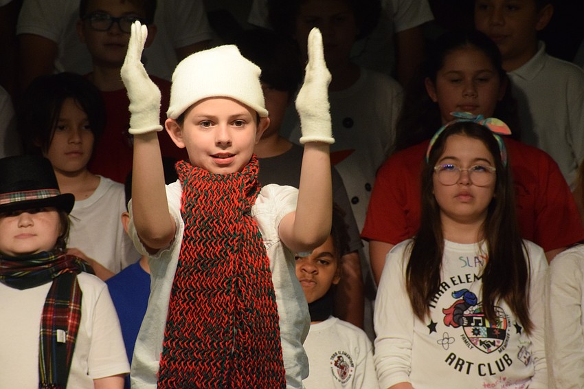 Samuel Moya, a fifth grader, puts all his energy into being a snowman in the play. He's guiding Santa's sleigh to a safe landing.