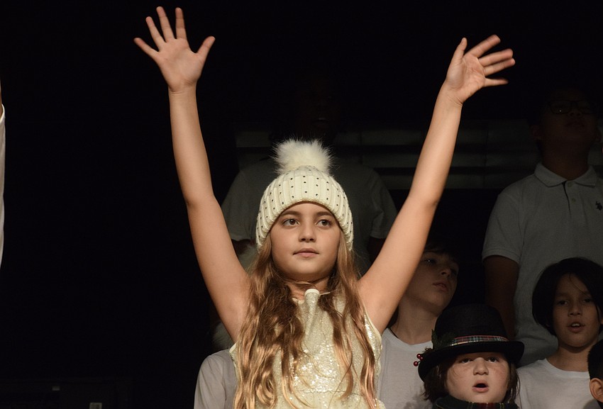 Mia Turasz, a fifth grader, sings and dances along with the other fifth graders dressed as snowmen.