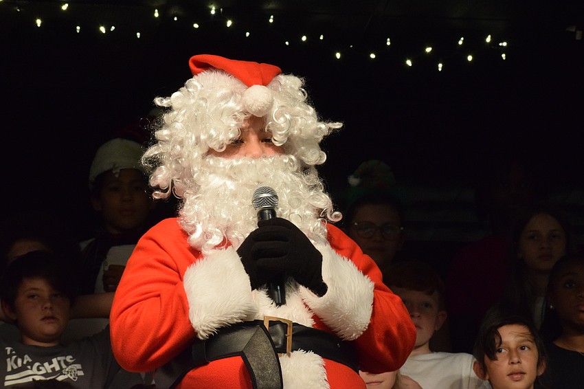 Javier Torres, a fifth grader dressed as Santa, wishes everyone a Merry Christmas.