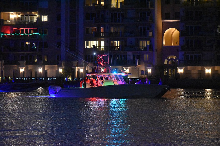 A brightly decorated boat dashes through the Marina Jack Yacht Basin area.