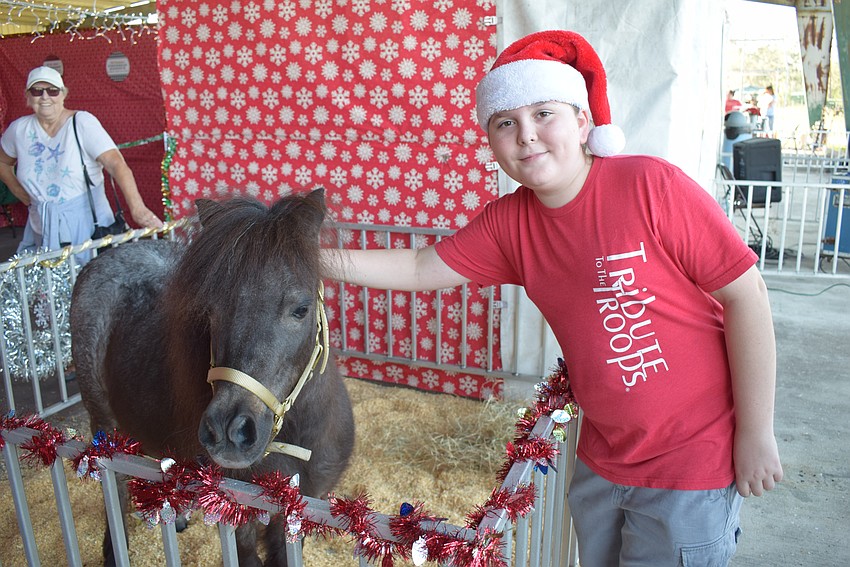 Willie, a miniature horse, visits with Port Charlotte's Walker Kohlenberg during a special Christmas event at Herrmann's Royal Lipizzan Stallions.