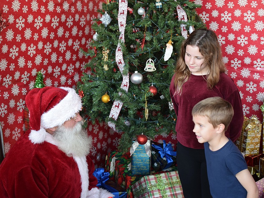 Parrish's Truitt Caggiano, 6, and Ella Caggiano, 9, enjoy a visit with Santa at Herrmann's Royal Lipizzan Stallions.