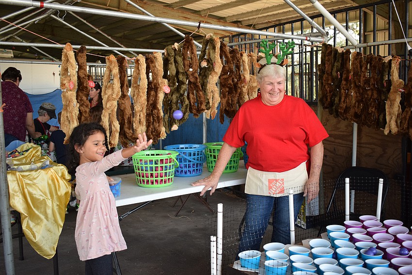 East County's Siena Williams, 5, attempts to win a prize while volunteer Shirley Bryant watches. Williams scored in the carnival game and brought home a prize.