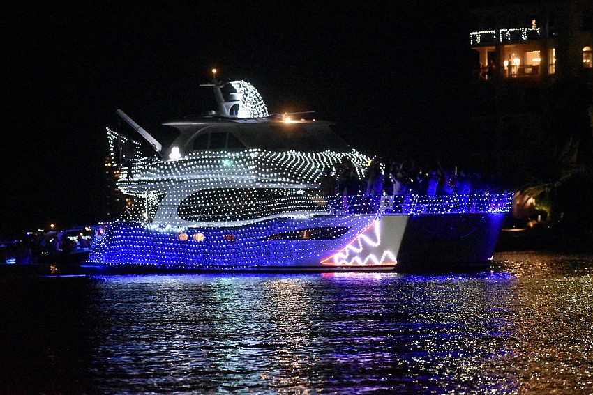 A brightly decorated boat dashes through the Marina Jack Yacht Basin area.