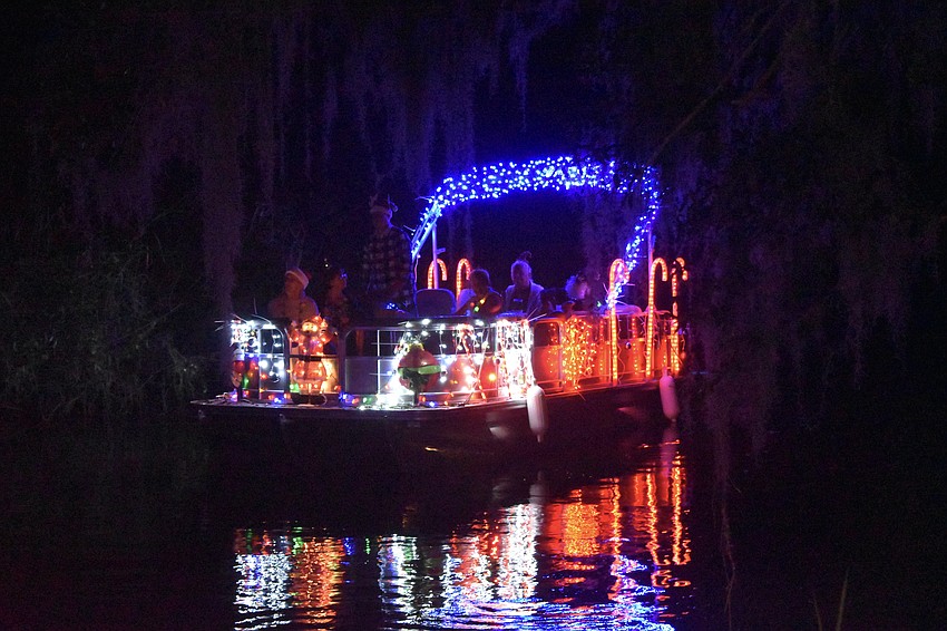 A boat approaches Linger Lodge during the Holiday Boat Parade.