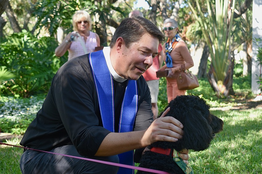 Rev. David Marshall blesses Reva, an 8-year-old labradoodle.