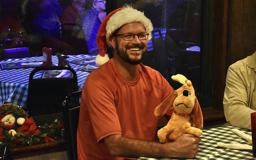 Mill Creek's Lewis Osborne, a Jiggs Landing employee, gets a turn to hold a plush Max which accompanied Tara's Dee Boenau and Jack Boenau on their Grinch-themed boat.