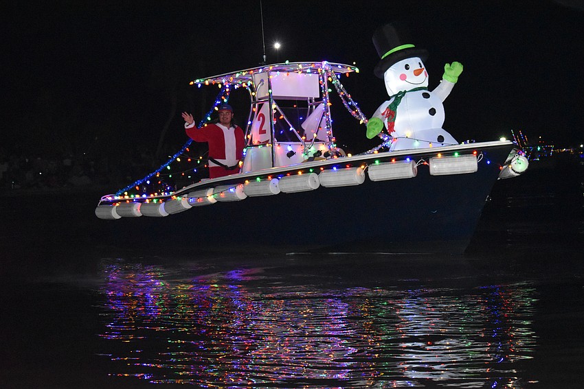A brightly decorated boat dashes through the Marina Jack Yacht Basin area.