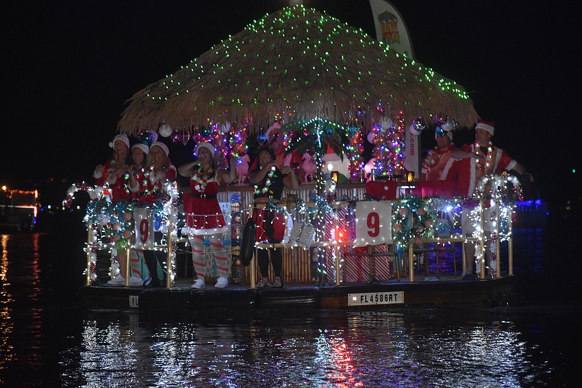 A brightly decorated boat dashes through the Marina Jack Yacht Basin area.