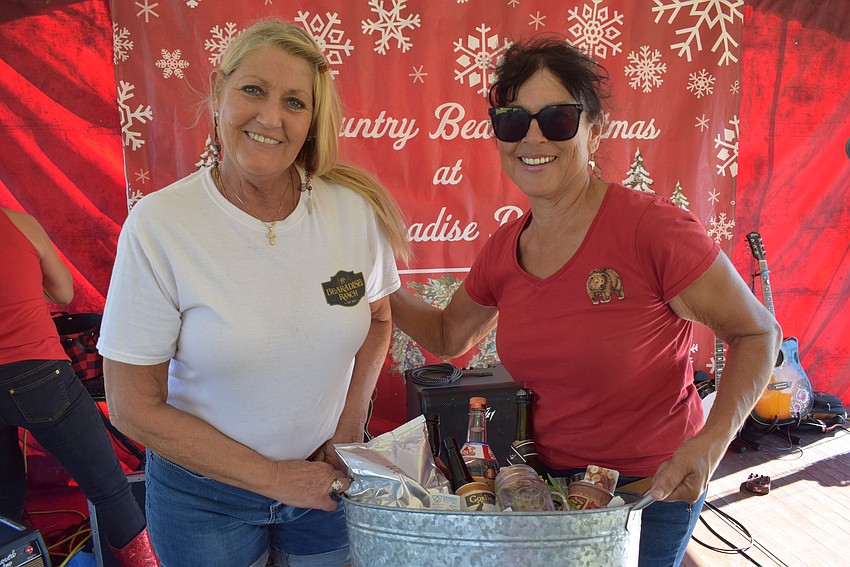 Bearadise Ranch volunteer Penny Lemon of Sarasota is presented a gift basket by Bearadise owner Monica Welde. Lemon won the raffle on Dec. 10.