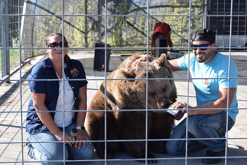 Monica Welde's daughter Jennifer Welde and her son Johnny Welde talk to the crowd and keep Carroll the bear happy with a little honey.