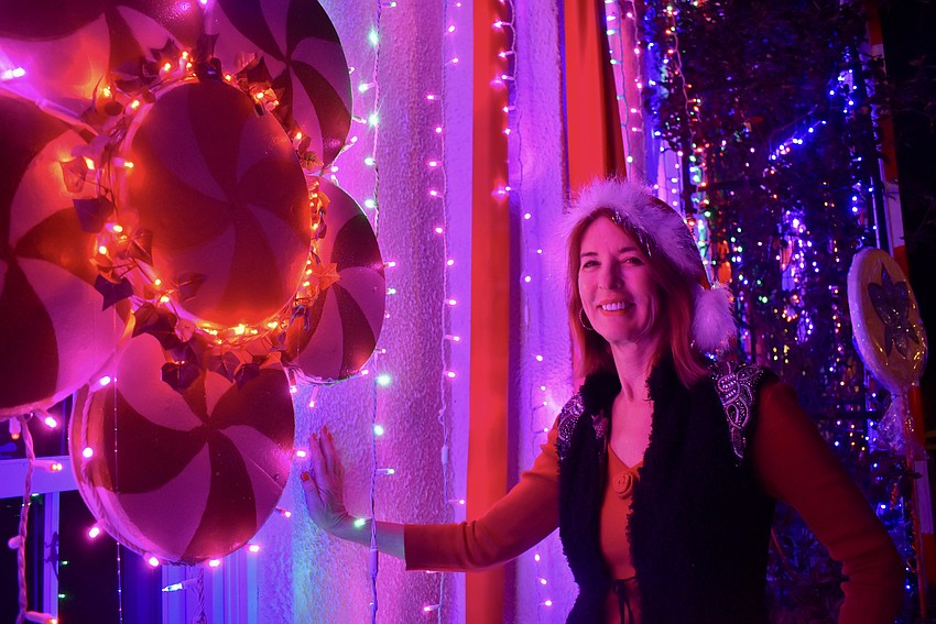 Penny Hill poses next to the historic Selby House façade that's transformed into a festive gingerbread house.