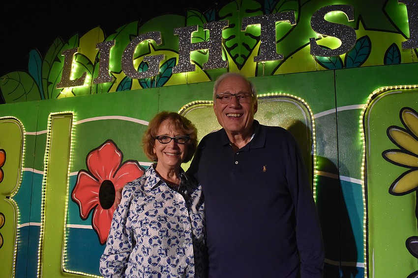 Bettianne and Hal Marcus pose in front of the Lights in Bloom billboard.