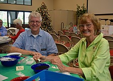 Brent Piersma and Beverly Sutton fill seed packets for Hope Seeds.