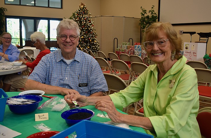 Brent Piersma and Beverly Sutton fill seed packets for Hope Seeds.