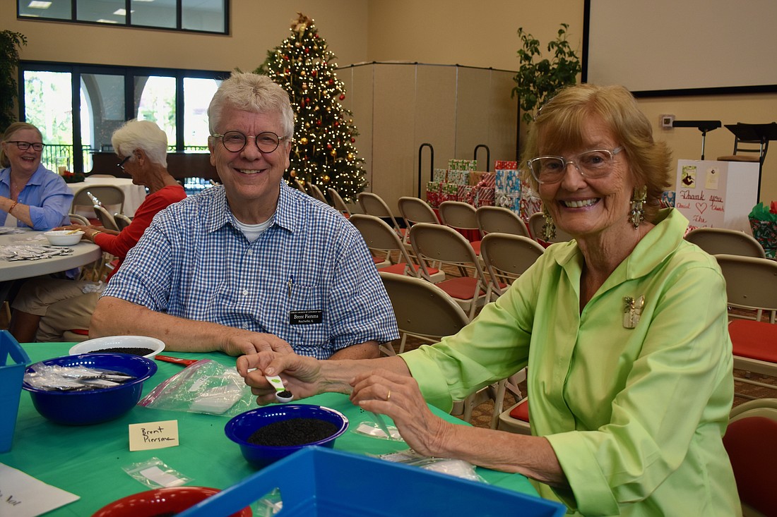 Brent Piersma and Beverly Sutton fill seed packets for Hope Seeds.