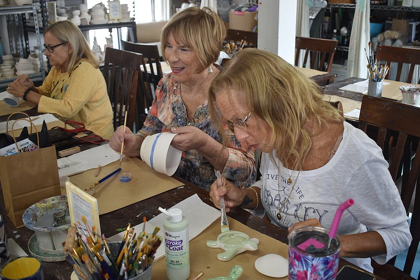 Valerie Evanko and Cari Aslan work on their ceramics.
