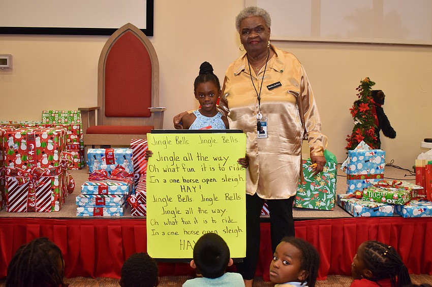 Leilani Bell and teacher Shirley Jackson help the crowd with lyrics.