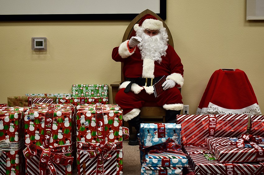 Santa waves to the children.