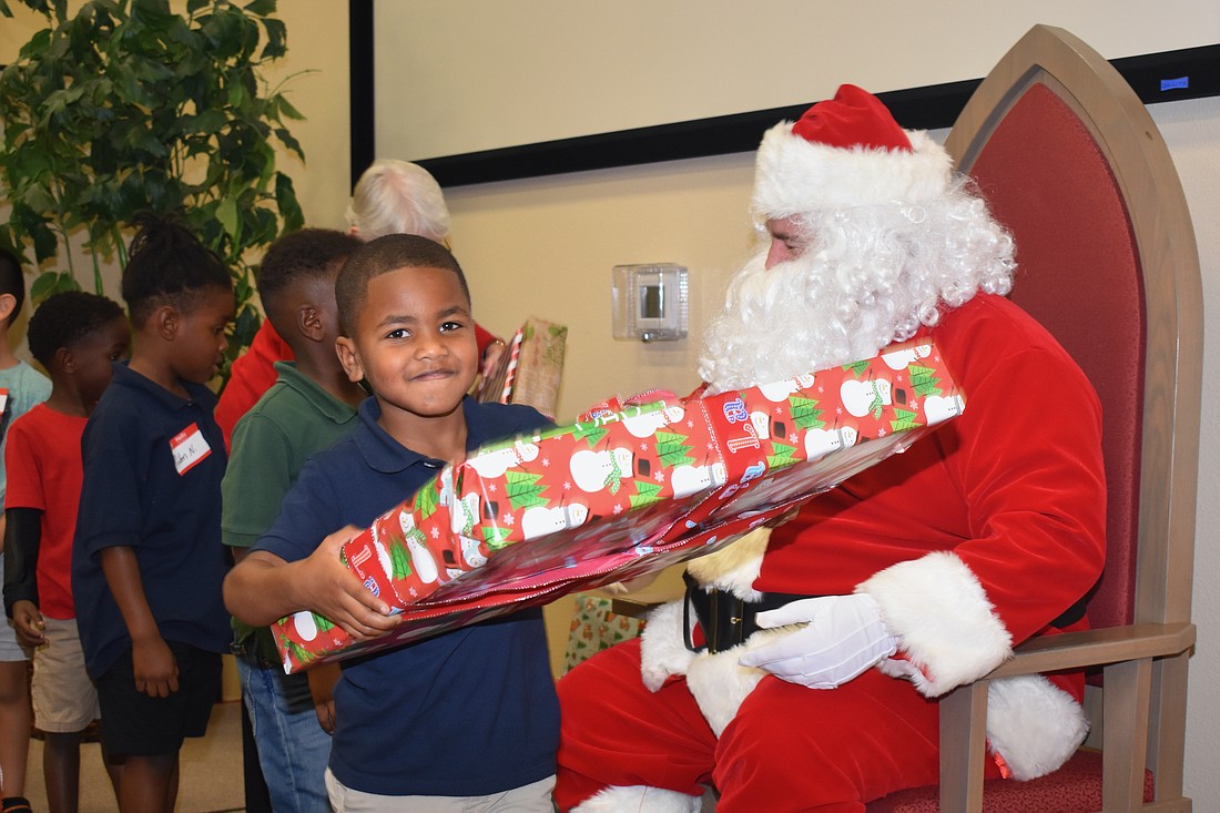 Peyton Washington happily accepts his gift from Santa.