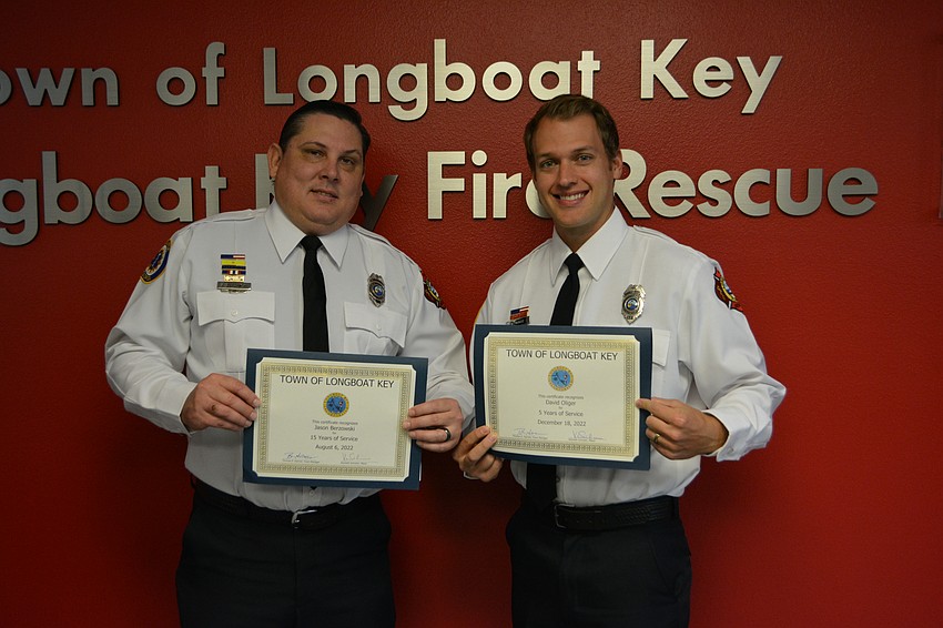 Firefighter/paramedics Jason Berzowski, left, and David Oliger received awards recognizing years of service with the department.