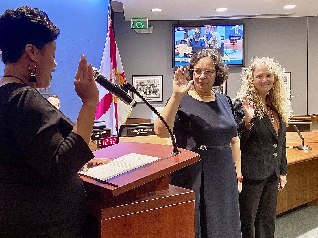 Debbie Trice (center) and Jen Ahearn-Koch being sworn in as city commissioners by City Auditor and Clerk Shayla Griggs.