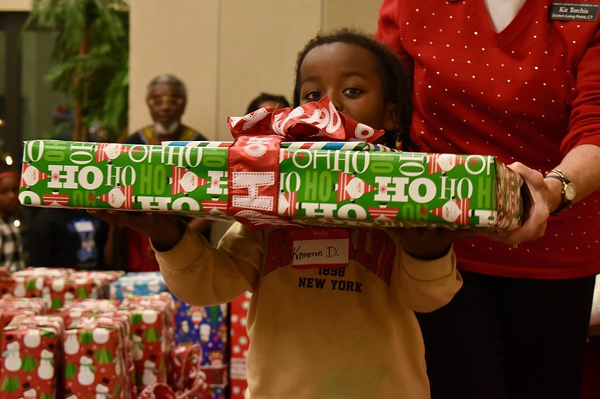 Kareem D. needs a little help. He and his gift are about the same size.