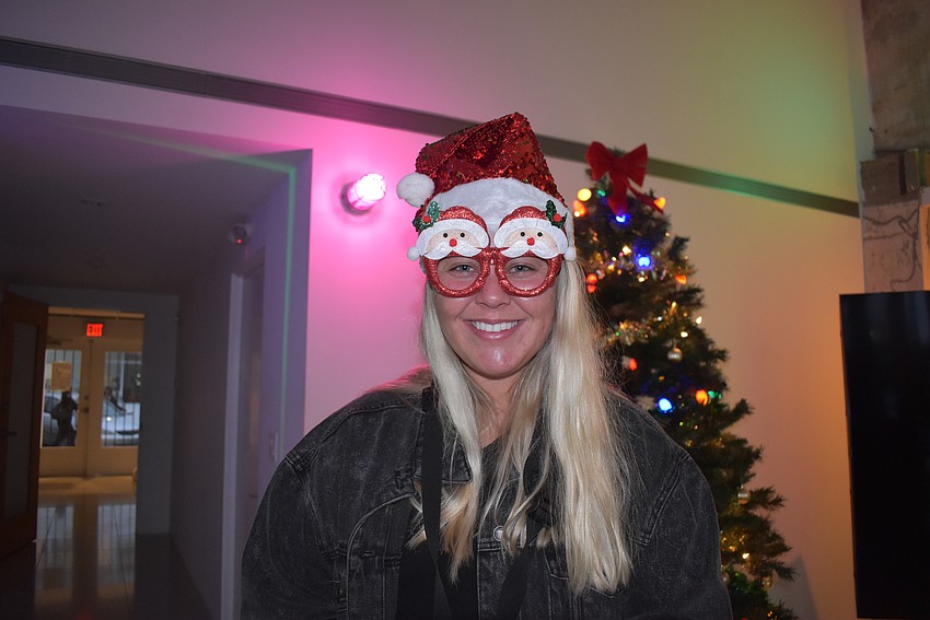 Sydney Baulier takes pictures of the crown in a Santa hat and glasses.