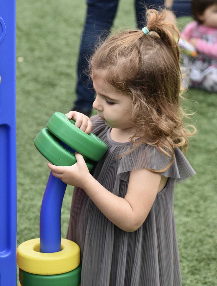 Lakewood Ranch's 2-year-old Audrey Cino plays a large Connect 4-style game.