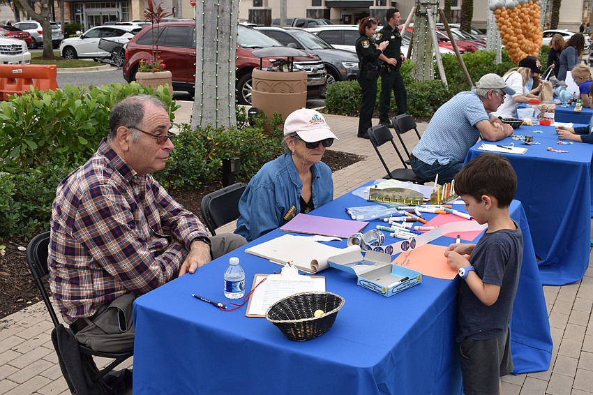 East County's Jim Germer and Sarasota's Ellyn Ingalls, both Temple Emanu-El volunteers, help Lakewood Ranch's 5-year-old Jacob Schwartz create a Hanukkah greeting card for residents of Aviva Senior Living in Sarasota.