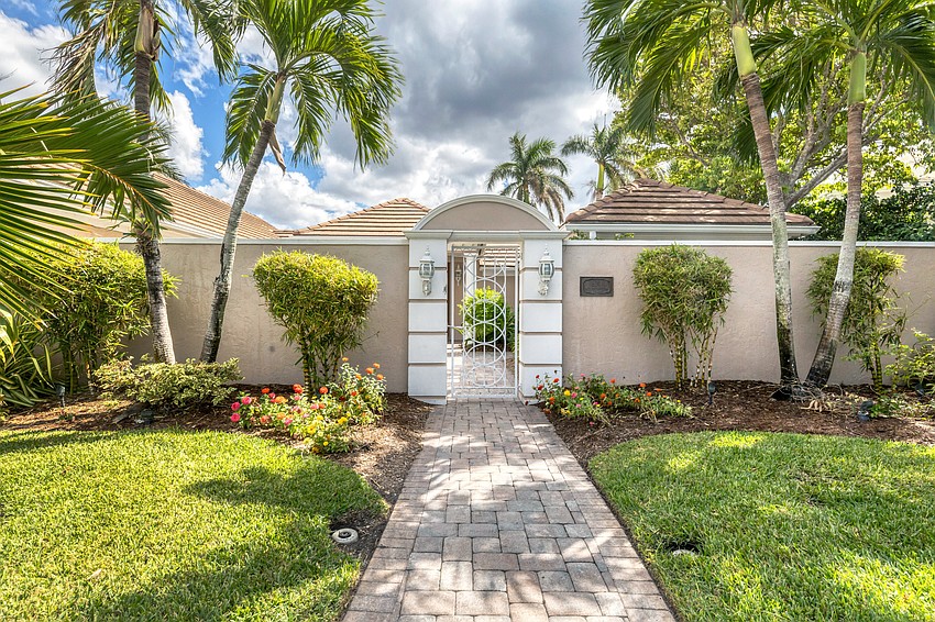Stone walkways and a wrought-iron gate leads to the main entrance.