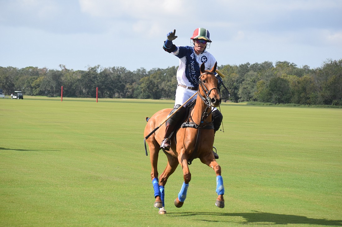 Stuart Campbell of the North South Wealth Management/Ranch Hand team waves to the crowd during the opening parade of the 2023 Sarasota Polo Club season on Jan. 1, 2023.
