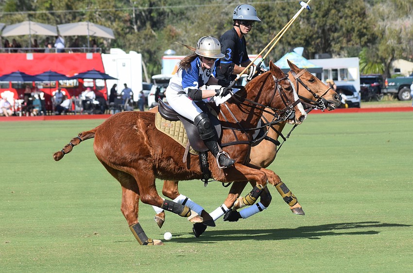Claire Dornak of North South Wealth Management/Ranch Hand tries to pass the ball down the field as Barefield/Hawkwood's Vasco Iriate challenges her in the season opener at the Sarasota Polo Club Jan. 1.