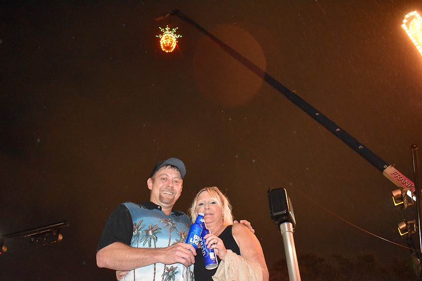 Brian and Norri Zeman make a toast under the pineapple.