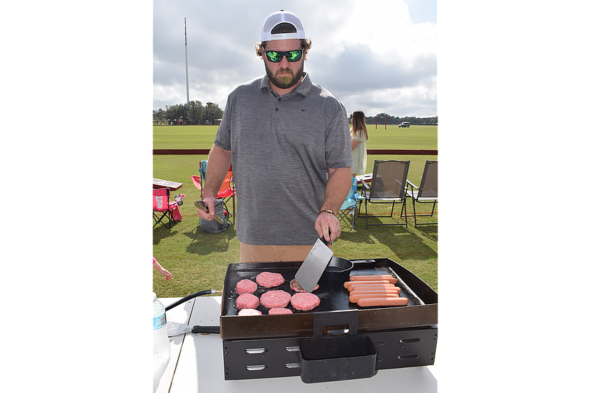Trent Compton os Lakewood Ranch drew the job of flipping burgers and hot dogs for his group on opening day at the Sarasota Polo Club Jan. 1.