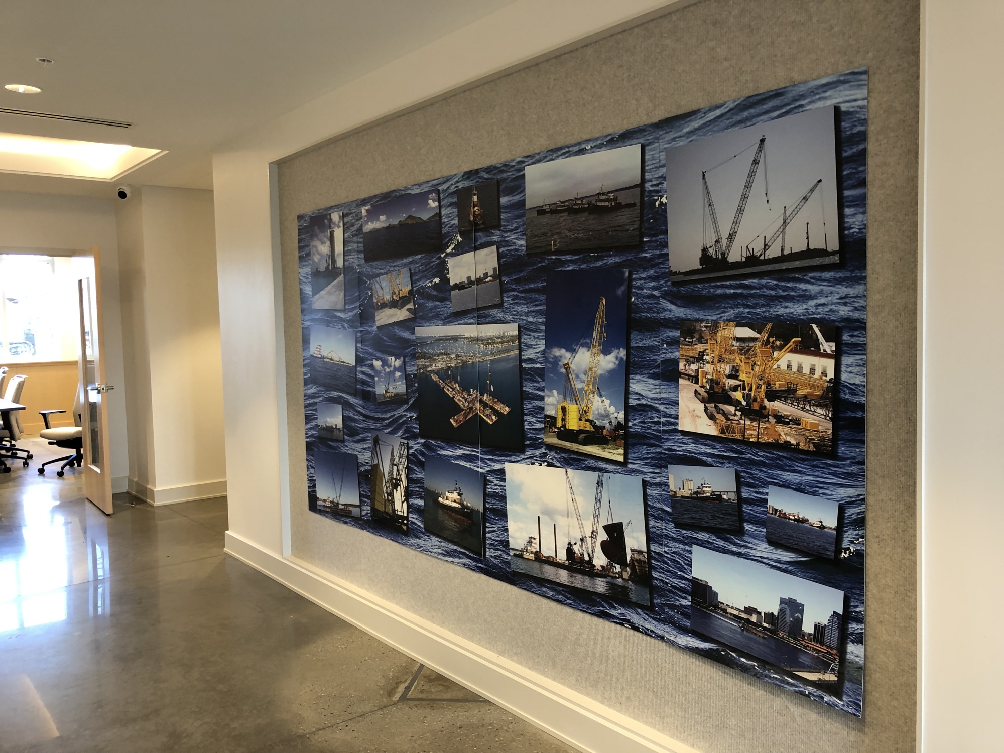 A montage of barge and crane photos on display in a hallway in Mobro Marine’s new office building in Green Cove Springs. More presentations like this are planned.