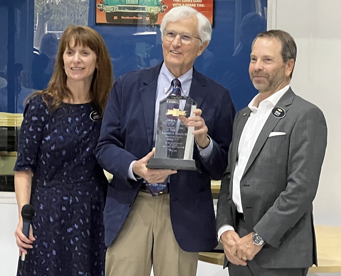 Lawrence Dimmitt III, center, was honored by General Motors Co. for leading Clearwater-based Dimmitt Chevrolet for 50 years. He is flanked by his wife, Elizabeth Dimmitt, and GM executive Steve Davis. (Courtesy photo)