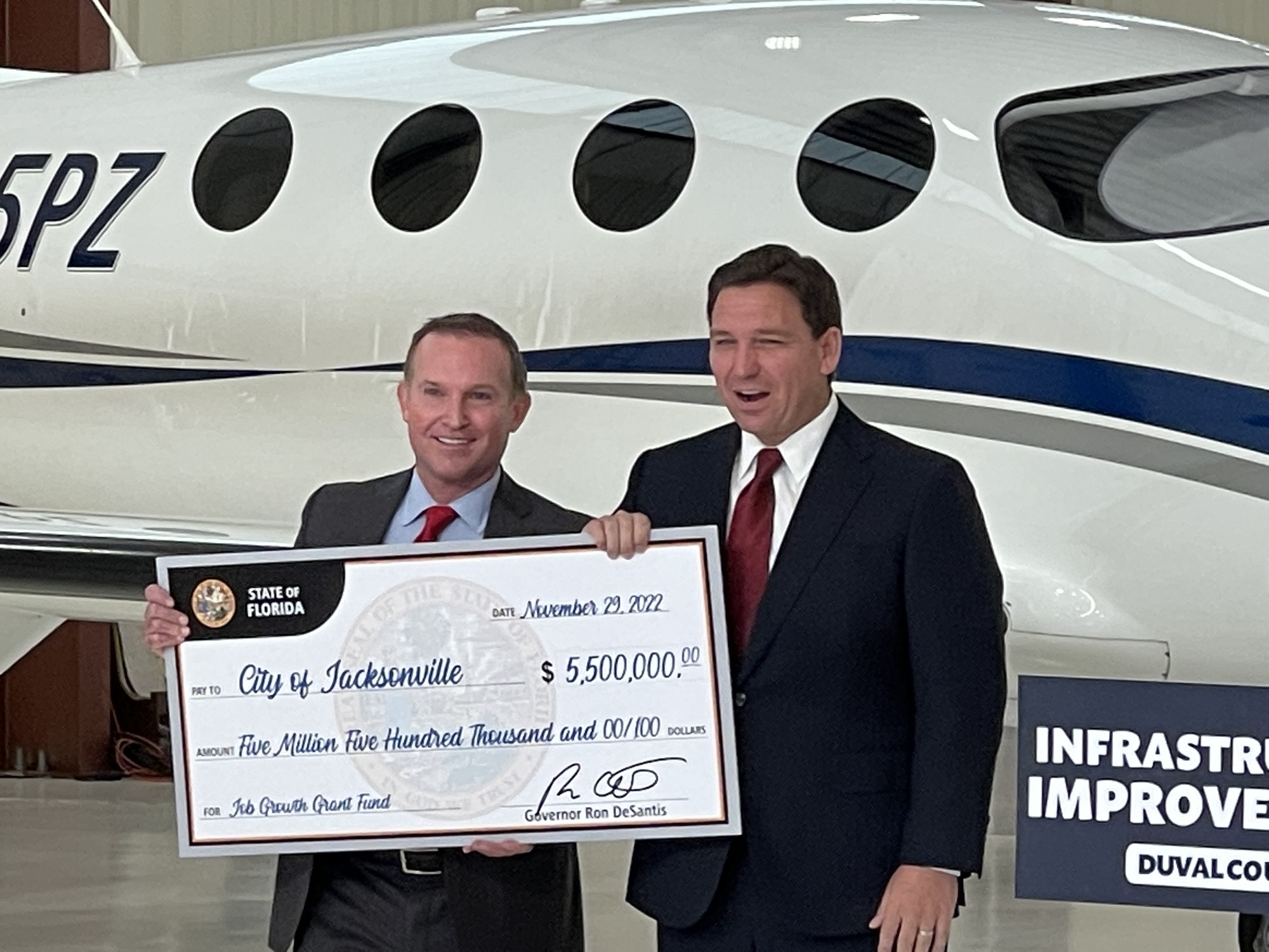 Jacksonville Mayor Lenny Curry and Florida Gov. Ron DeSantis and show off the $5.5 million check at the news conference
