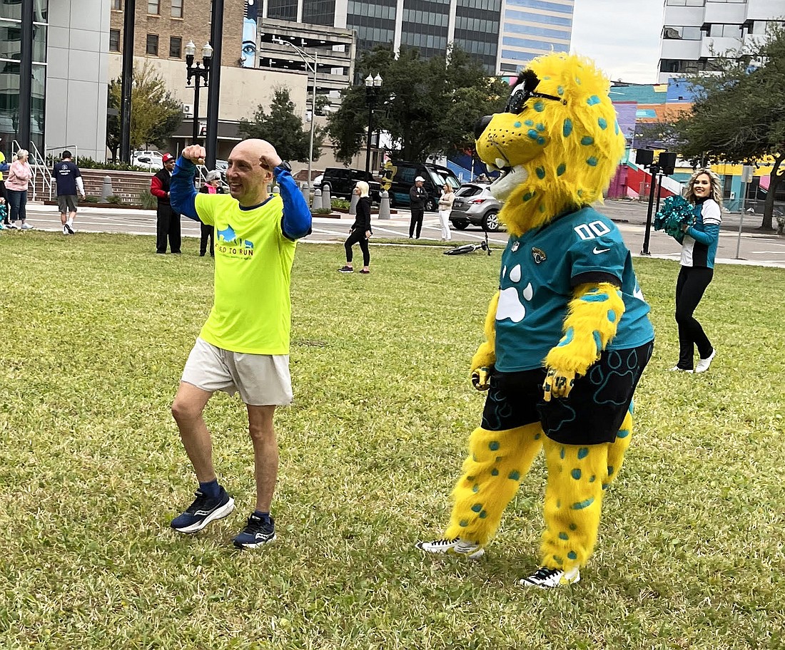Jacksonville Jaguars mascot Jaxson de Ville welcomes Mike Freed across the finish line at Freed to Run 6.0.