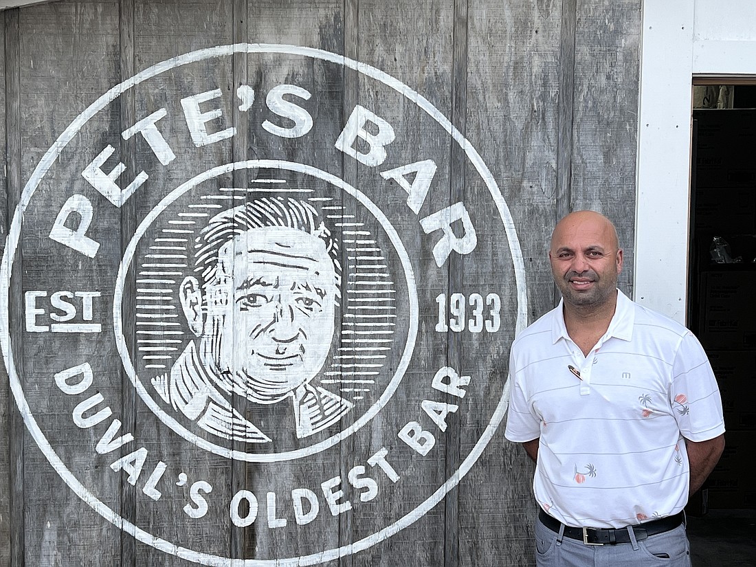 Partner Shahab Derazi stands next to a logo depicting Peteâ€™s Bar founder Peter Jensen.