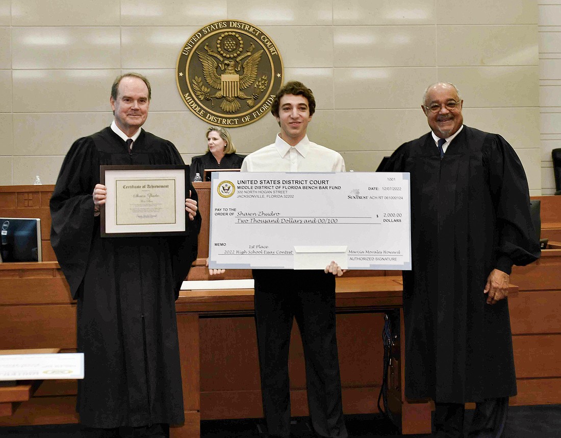Chief U.S. District Judge Timothy Corrigan, left, and U.S. District Judge Brian Davis presented the first place prize to Shaun Zhudro, a student at Flagler-Palm Coast High School and winner of the 2022 High School Essay Contest.