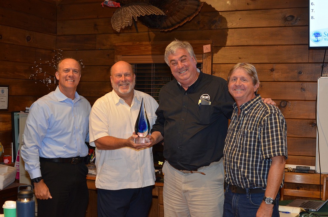 Dr. Erich Marzolf, third from left, received an award from FOLA for his restoration work in Lake Apopka. With him are Daniel Whitehouse, FOLA president; Joe Dunn, FOLA past president; and Jim Peterson, FOLA science advisor.