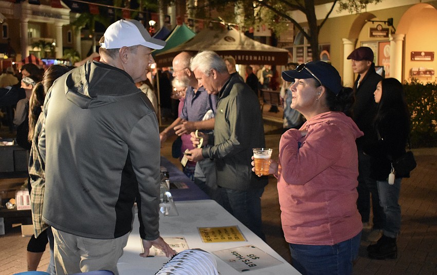 Scott Carpenter, husband of Beyond the Spectrum's executive director, Lora Carpenter, serves Bud Light to Creekwood's Danielle Santoro.