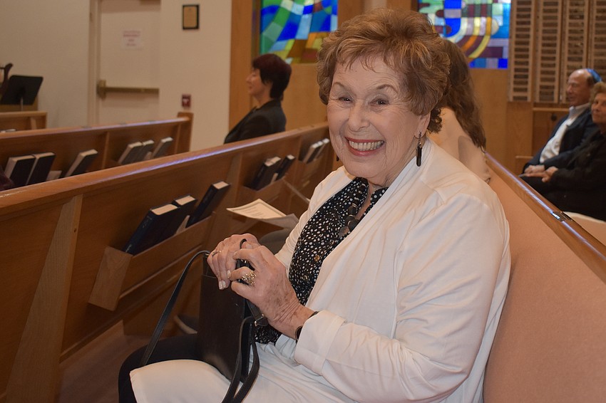 Carole Singer happily waiting on her husband of 69 years to sit and Shabbat service to start.