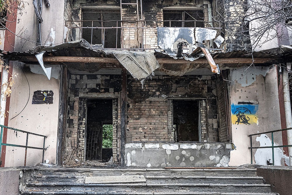 A spray-painted Ukrainian flag defies the Russian terror and destruction.