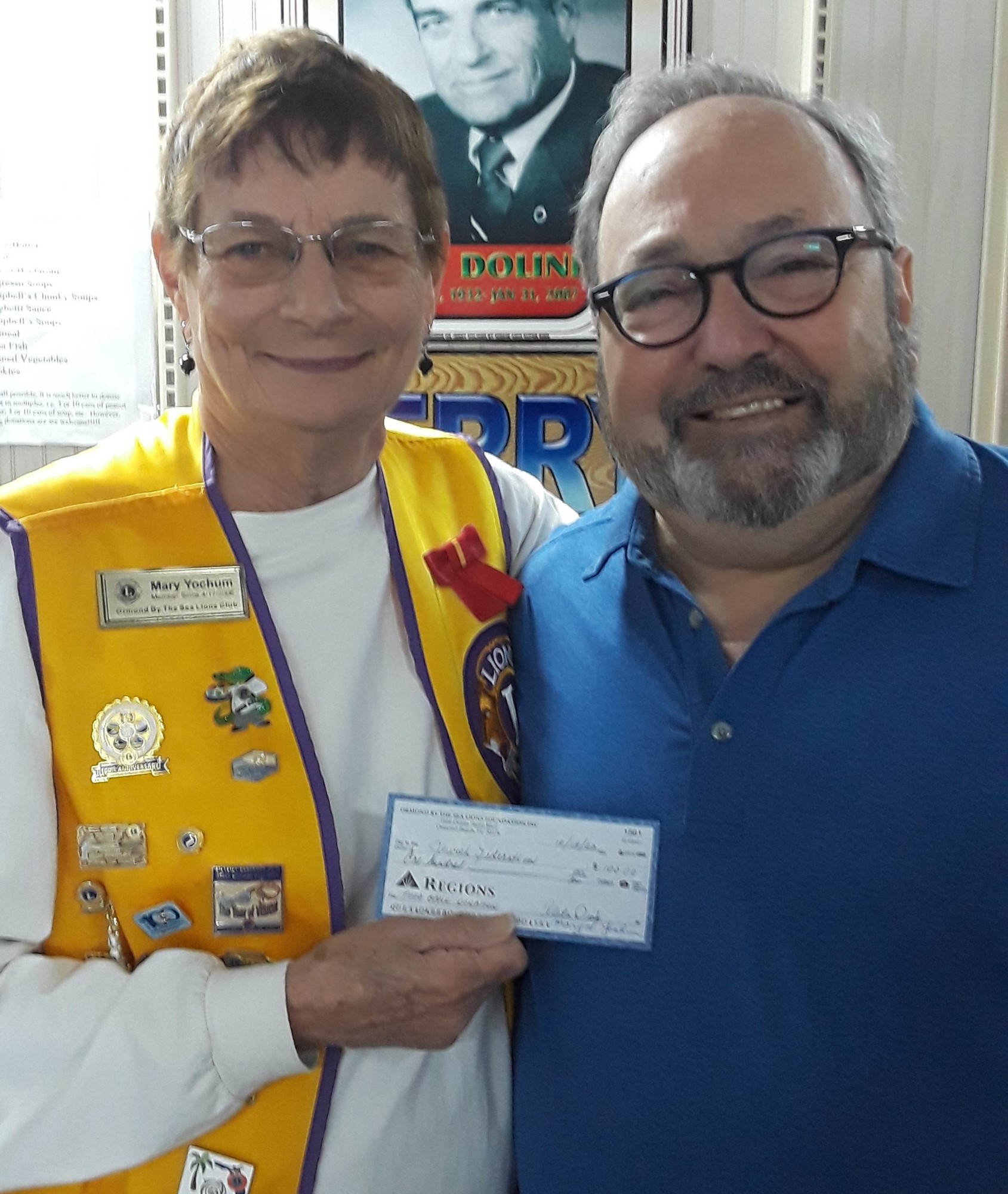 Lion Mary Yochum presents a $100 check to Jewish Federation Executive Director Rob Lennick. Courtesy photo