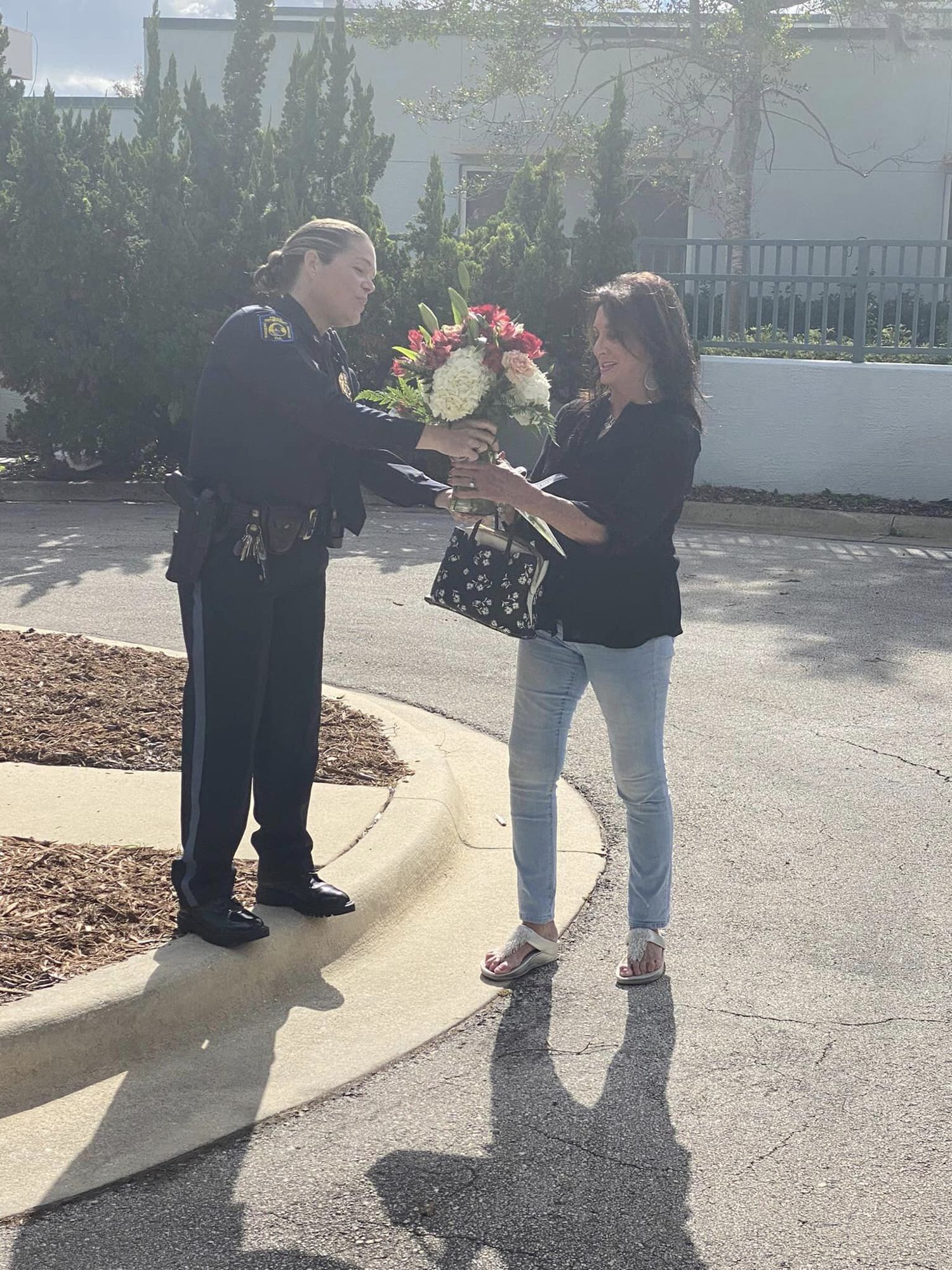Lt. Michelle Willis presents one of Grim's family members with flowers.  Photo courtesy of OBPD/Facebook